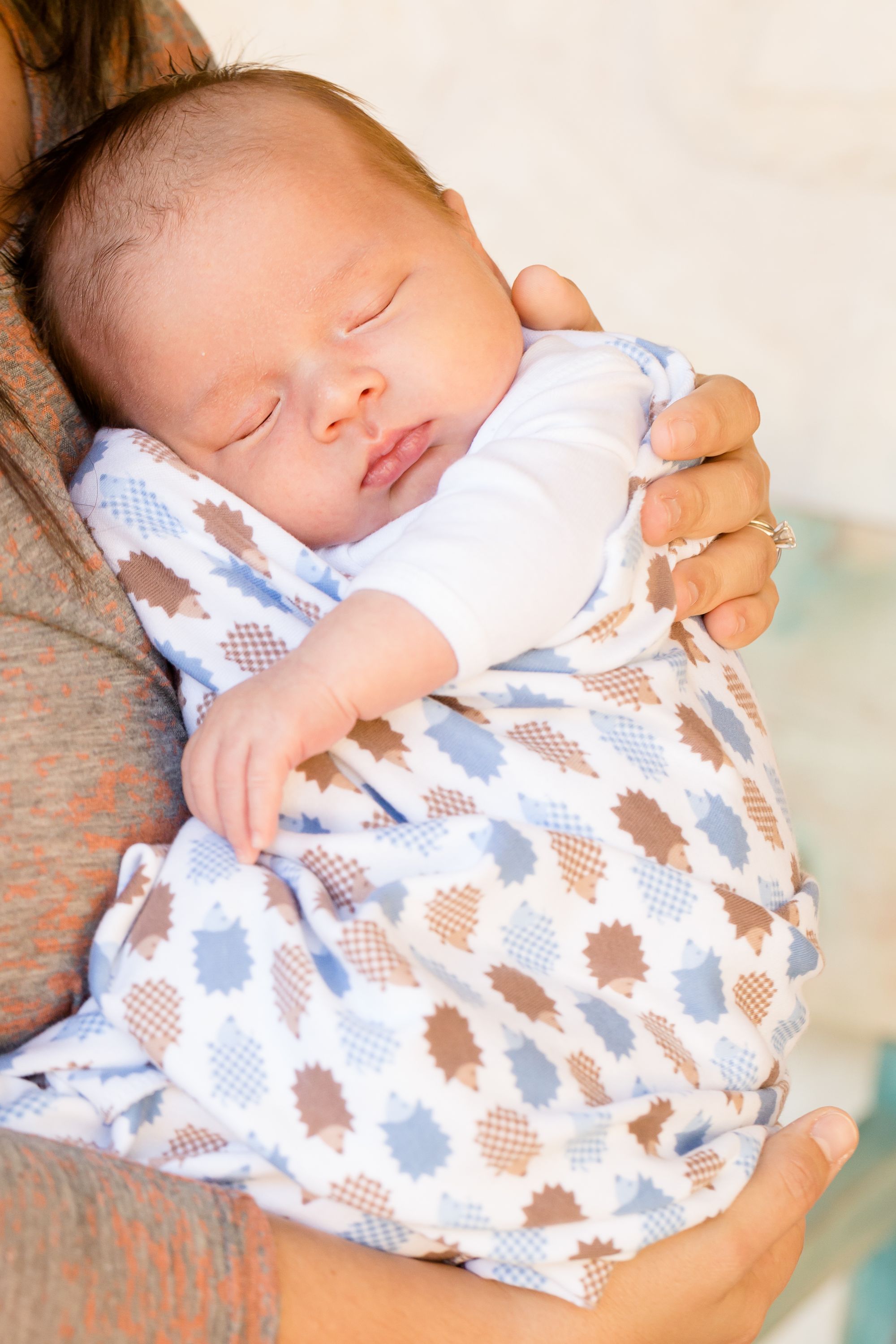 a baby sleeping in a person's arms