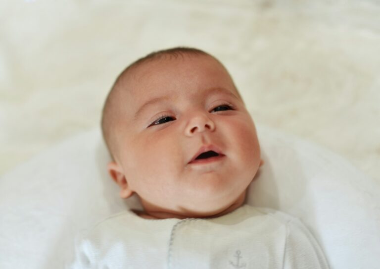 bebe de 3 mois en train de sourire dans son berceau