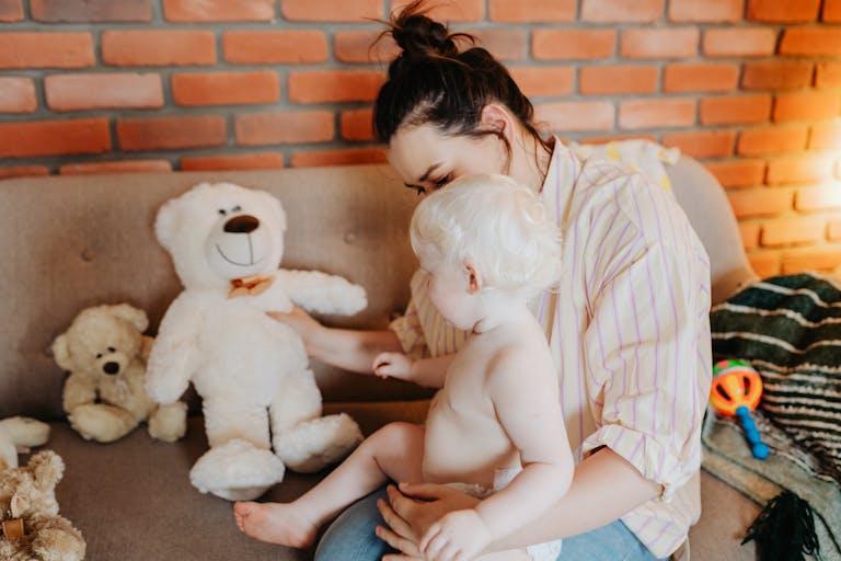 Woman Sitting on Brown Couch with Her Baby