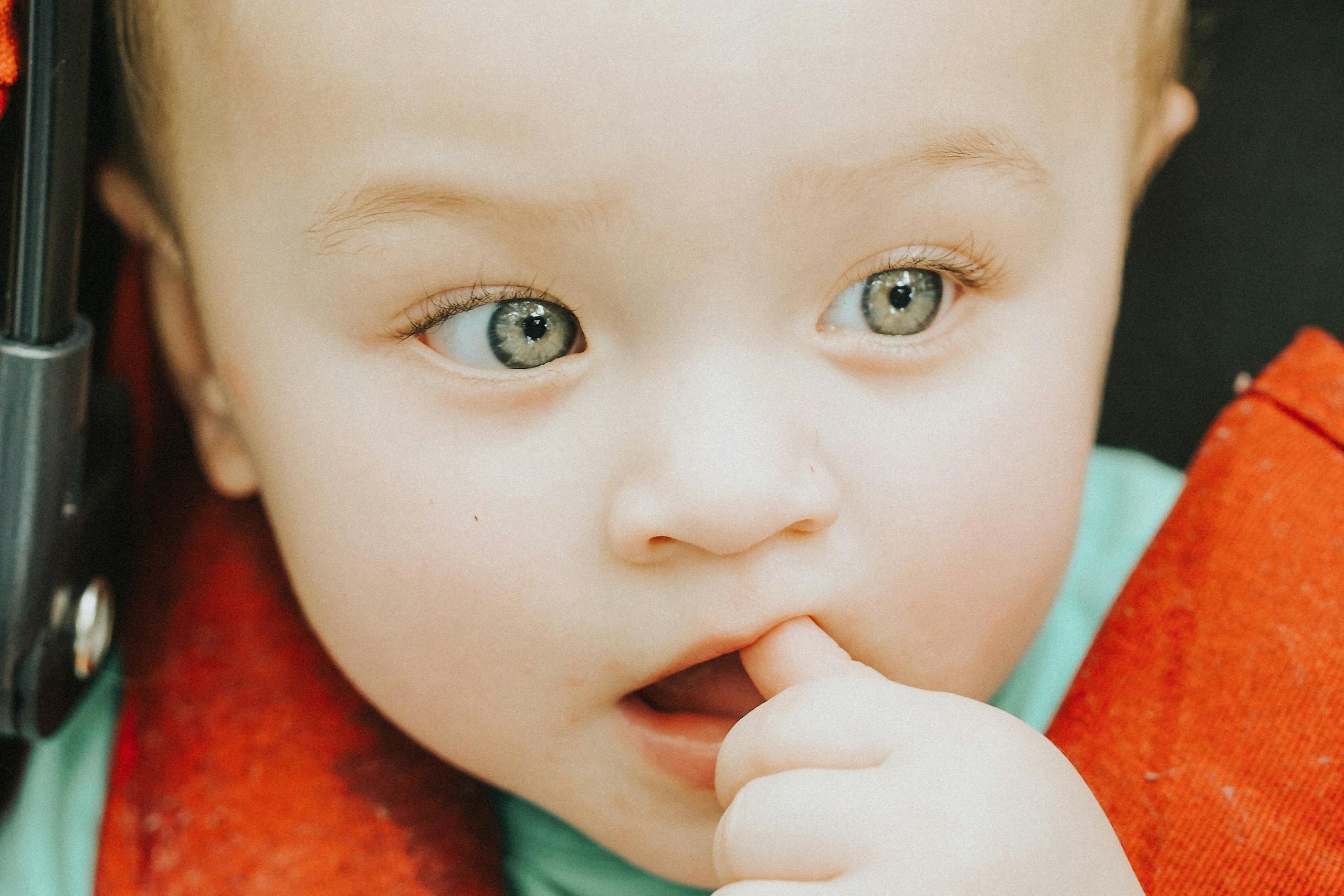 Couleur des yeux d'un bébé avec le pouce dans la bouche