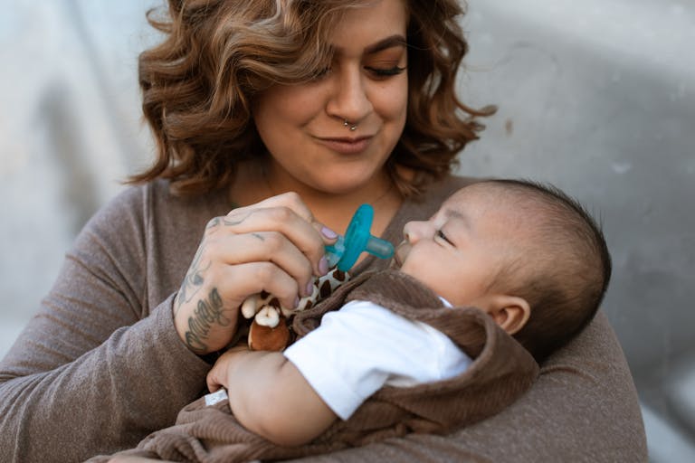 maman-donne-tetine-bebe-avec-sucette-nouveau-ne-de-couleur-bleu