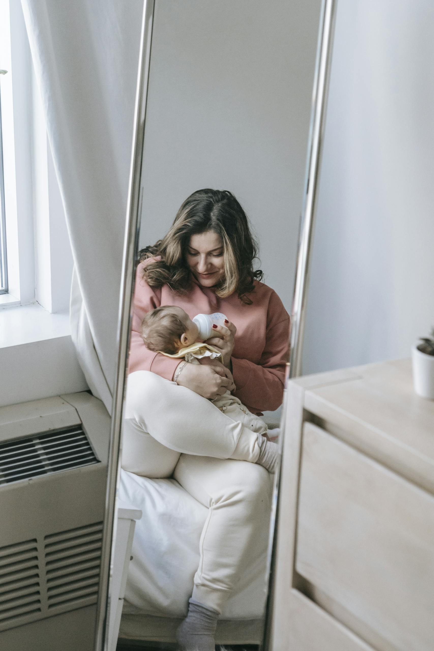 bébé-boit-biberon-donne-par-maman-avec-un-effet-miroir