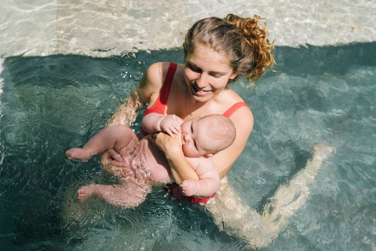 bébé-dans-piscine-avec-maman-pratiquant-le-réflexe-de-nage