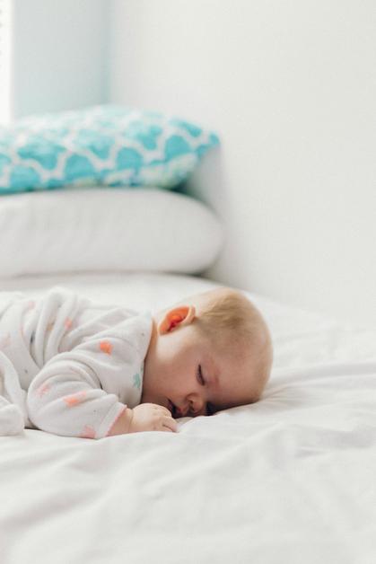 Bébé dormant sur le lit de drap blanc après avoir toussé