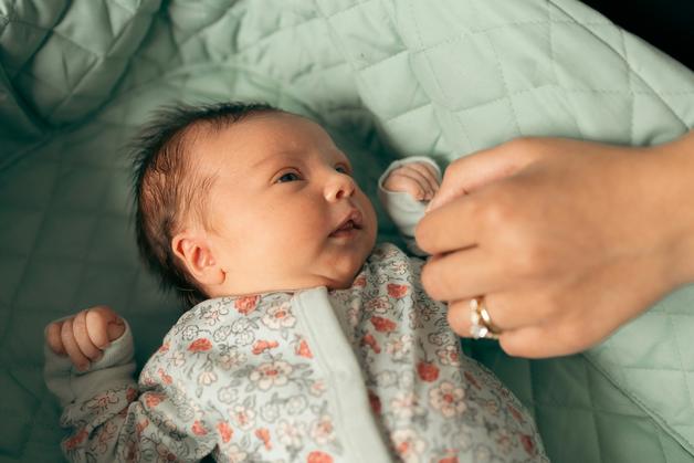 Bébé souriant pendant qu'on lui chante une douce berceuse bébé.