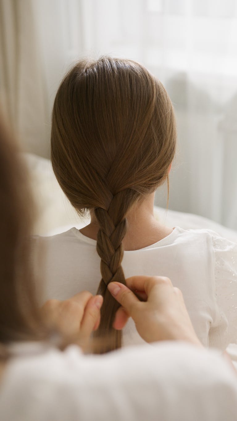 cheveux-enfants-tresser-par-main-d'adulte