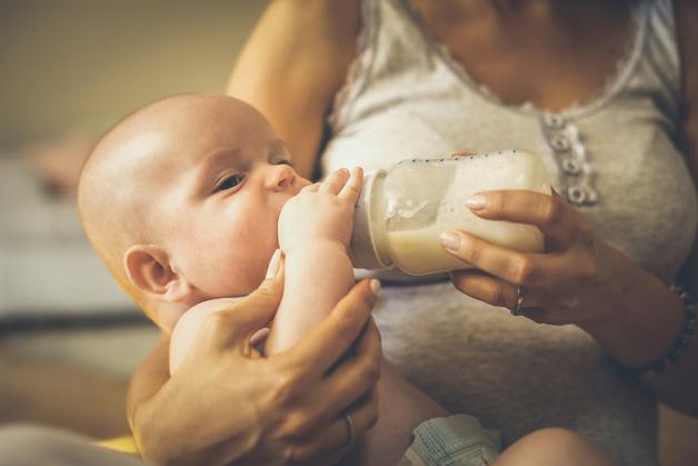 Bébé en train de boire au biberon, illustrant la règle d'appert sur l'alimentation infantile.