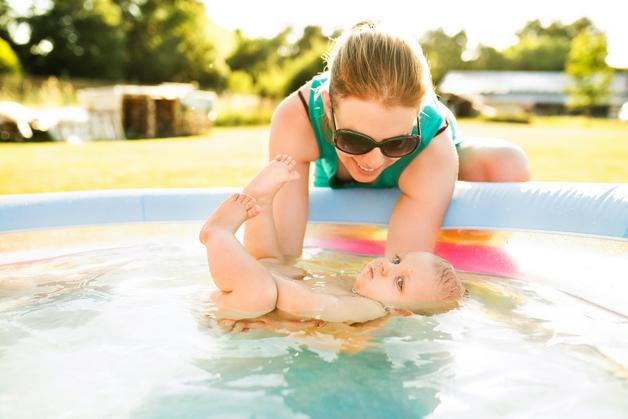 Mère et enfant jouant ensemble dans une couche piscine, profitez d'un moment de détente et de fun en été.