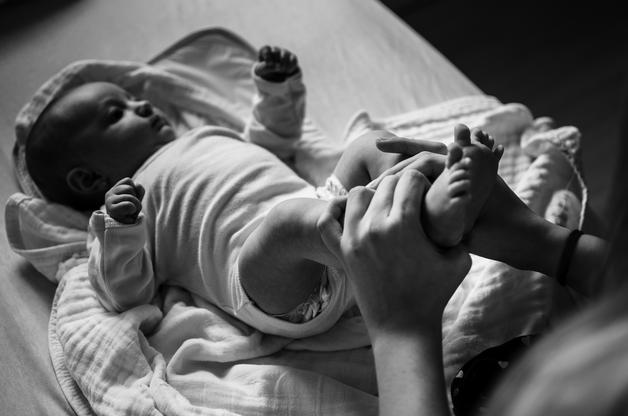 Bébé allongé, recevant des soins, observant la présence de glaire dans les selles bébé.