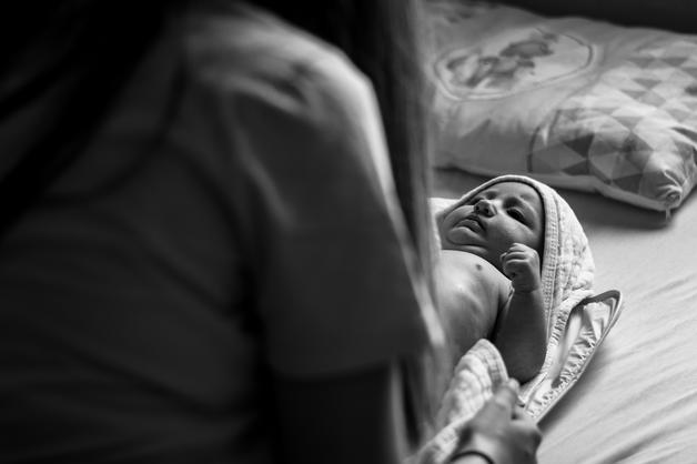 Bébé allongé dans un lit, observant sa mère, présentant des signes de jaunisse du nourrisson.