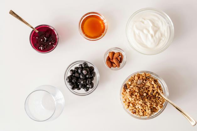 Bol de granola avec fruits, yaourt et petits pots de confiture, idéal pour un petit suisse bébé.