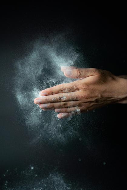 Des mains se frottent ensemble, libérant du talc bébé en poudre, symbolisant douceur et protection pour les tout-petits.