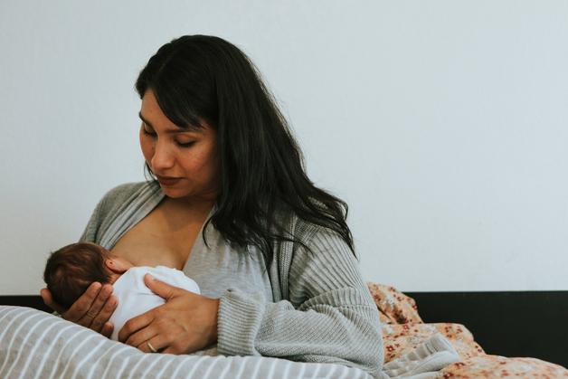 Mère allaitant son bébé, ressentant une gêne due à un téton douloureux.