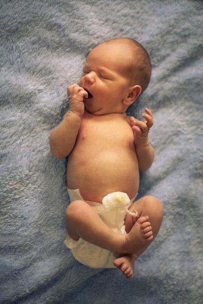 Bébé allongé sur un tapis, montrant des signes de vomissement en jet bébé, avec des gestes d'inconfort.