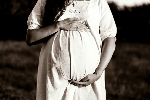 Femme enceinte en robe blanche, illustrant le thème du VME accouchement.