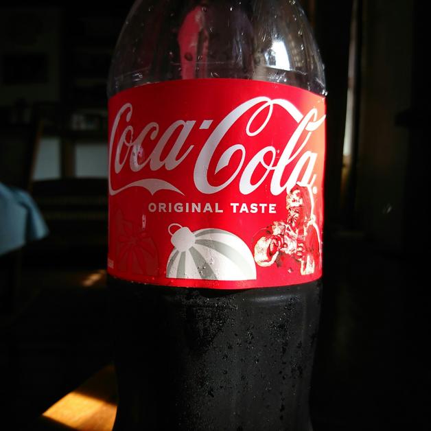 Bouteille de Coca-Cola posée sur une table, évoquant la question du coca enceinte et ses effets pendant la grossesse.