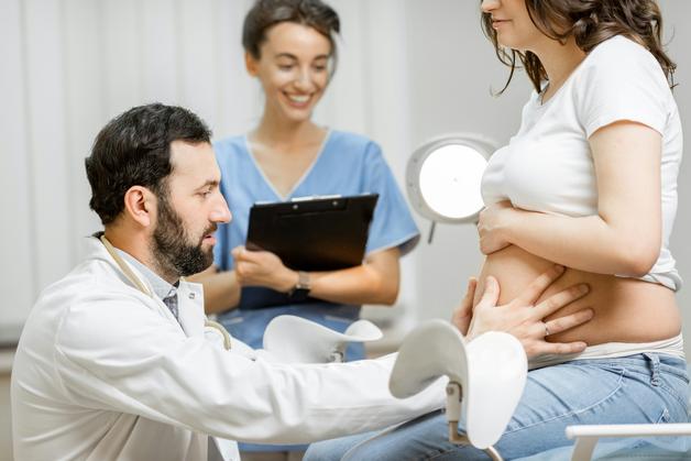 Femme enceinte examinée par un professionnel de santé, se plaignant de coliques au début de la grossesse