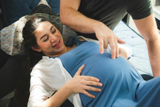 Femme enceinte souriante se préparant pour un déclenchement accouchement avec un partenaire attentif.