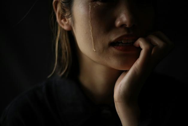 Femme exprimant la douleur de l'accouchement, avec une larme sur sa joue, illustrant les défis émotionnels et physiques.