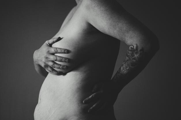 Femme enceinte se tenant le ventre, illustrant l'essoufflement grossesse.