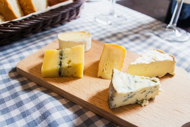 Assortiment de fromages sur une planche en bois, idéal à déguster pendant la grossesse, attention aux fromages enceinte.