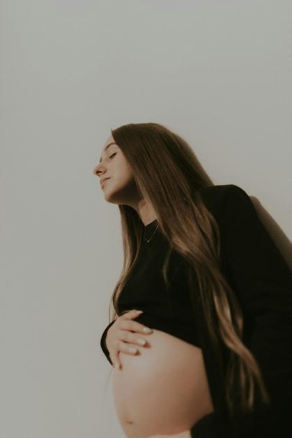 Femme enceinte se tenant le ventre, illustrant les effets de l'hypersalivation grossesse.