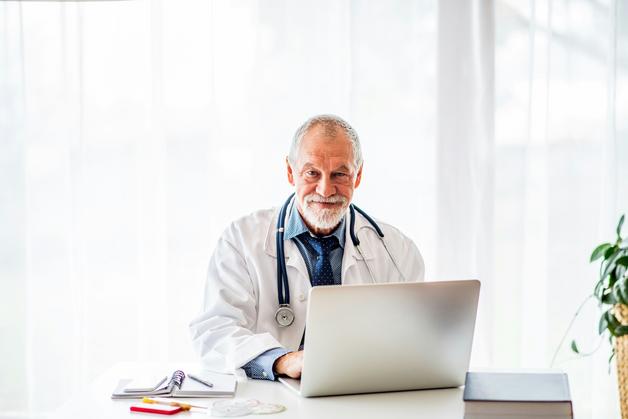 Médecin consultant sur la listériose grossesse, examinant des informations médicales sur un ordinateur.