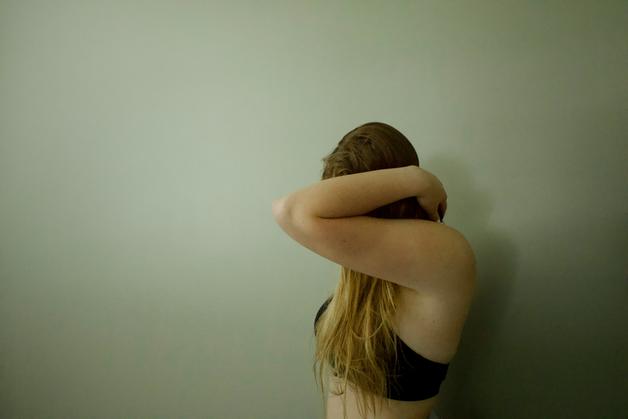 Jeune femme se tenant la gorge, éprouvant des douleurs, illustrant le mal de gorge enceinte.