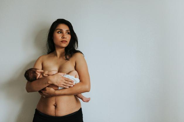 Femme tenant un bébé tout en ressentant des maux de tête enceinte, illustrant les défis de la maternité.