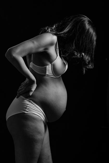 Femme enceinte se tenant le dos, illustrant les nausées intermittentes grossesse.