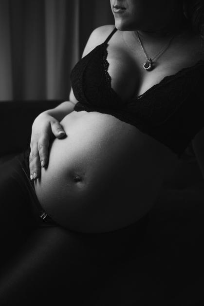 Femme enceinte exprimant des douleurs de pubalgie grossesse en se tenant le ventre.
