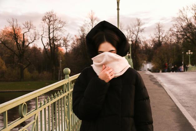 Femme enveloppée dans un foulard, se protégeant du froid pour éviter un rhume enceinte.