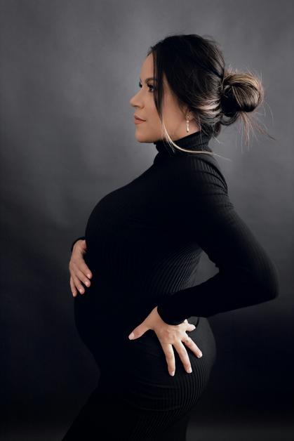 Femme enceinte en profil, touchant son ventre, souffrant de sciatique enceinte.