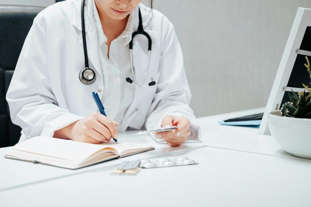 Médecin analysant le taux HCG jumeaux dans un carnet de santé.