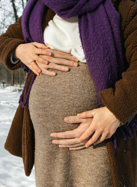 Femme enceinte caressant son ventre, illustrant les varices vulvaires grossesse.